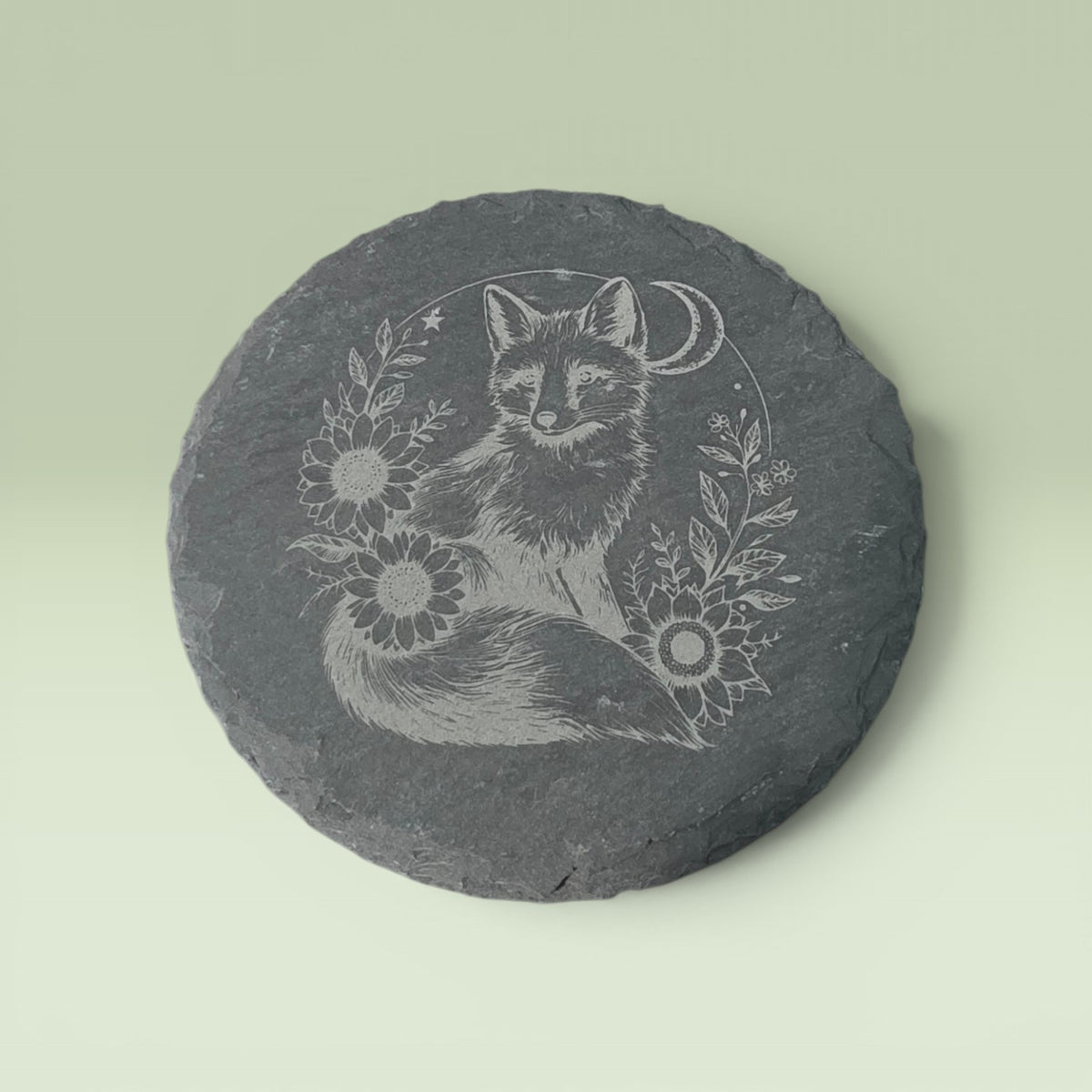 a grey stone with a drawing of a fox and flowers