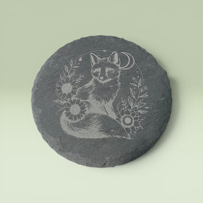 a grey stone with a drawing of a fox and flowers